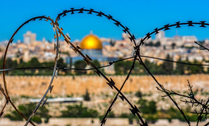 Im Vordergrund Stacheldraht im Hintergrund die Altsdtadt von Jerusalem mit der Al-Aqsa-Moschee.
